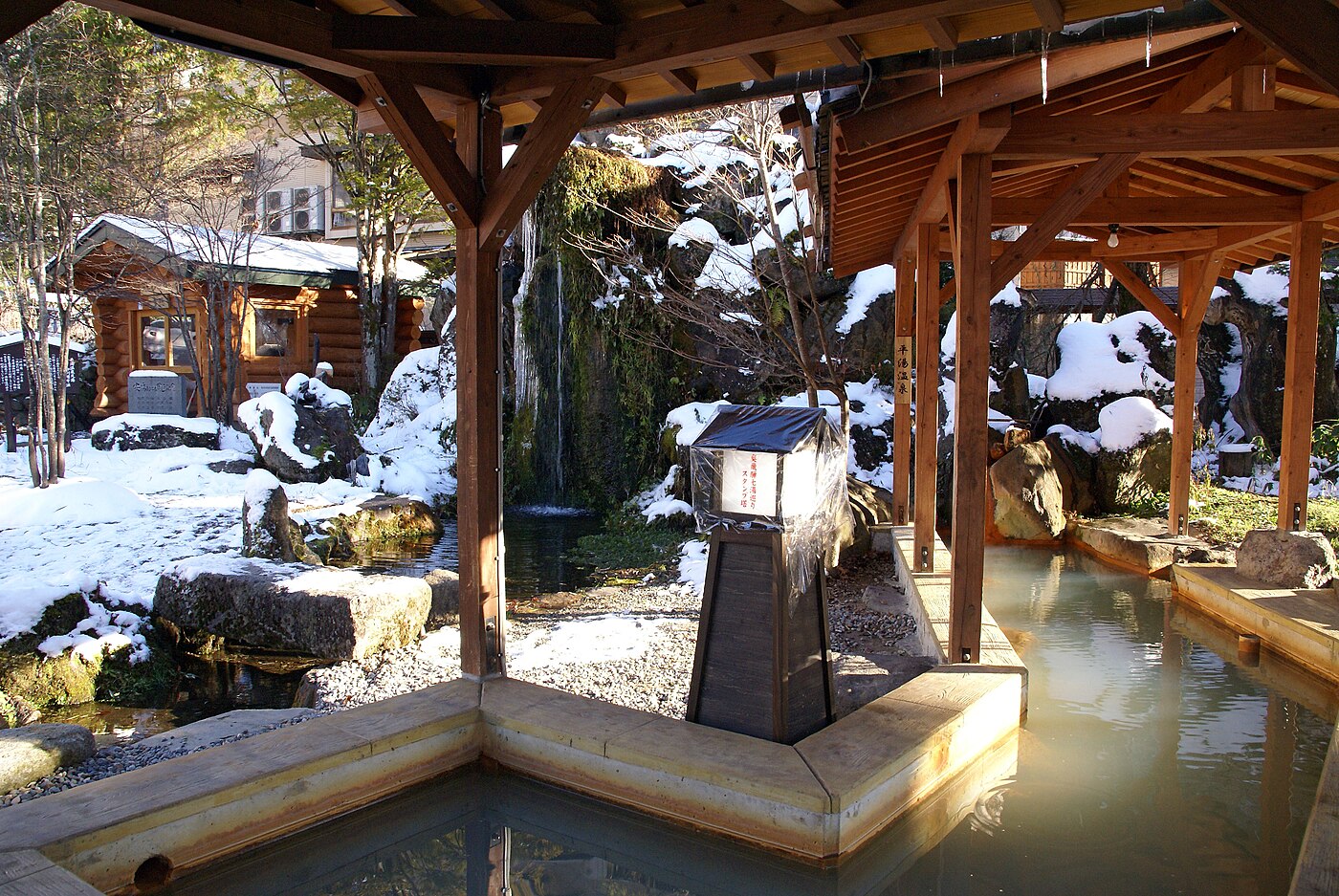 雪の残る平湯温泉の湯と湯けむり