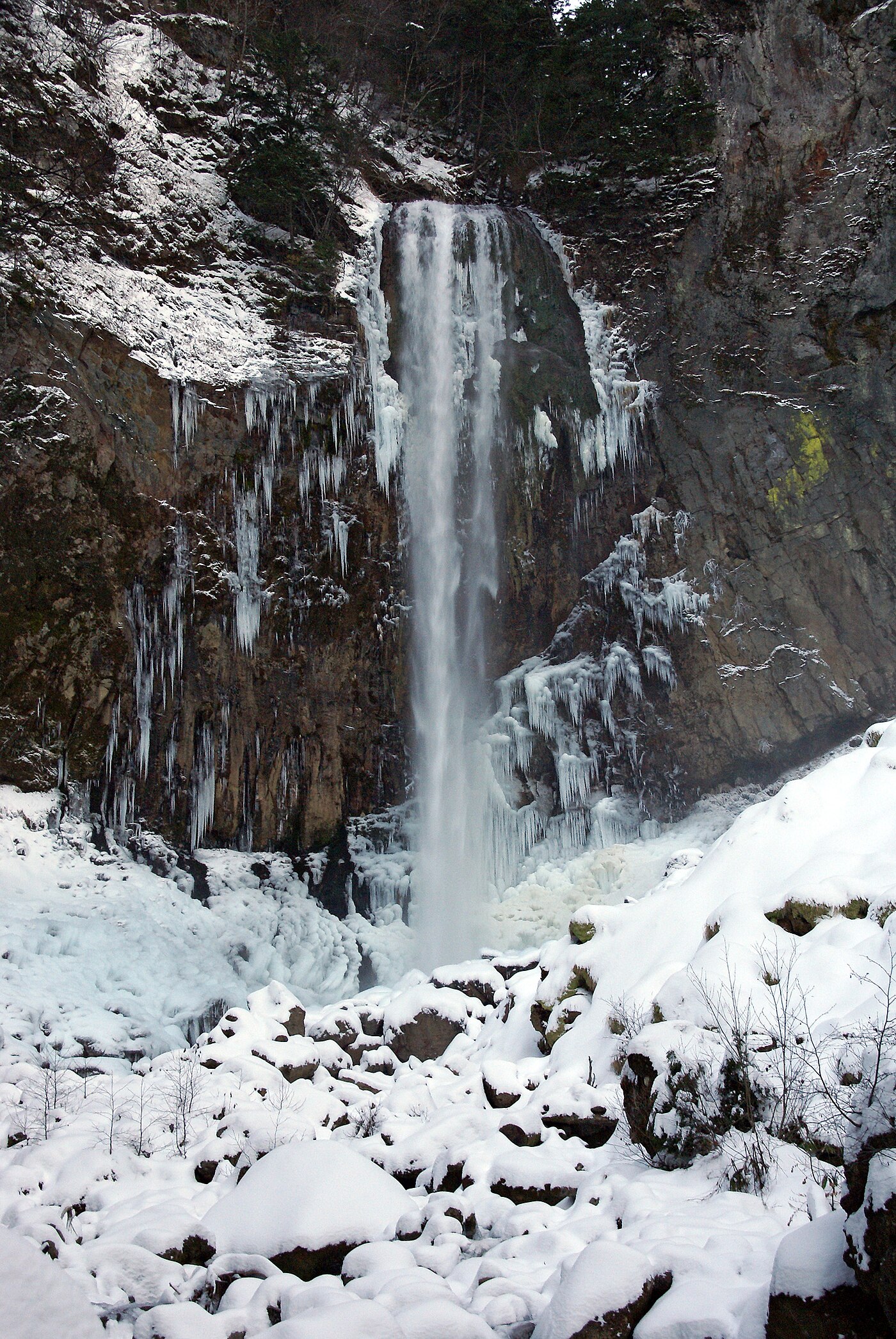 冬の平湯大滝と岩肌に育った氷柱